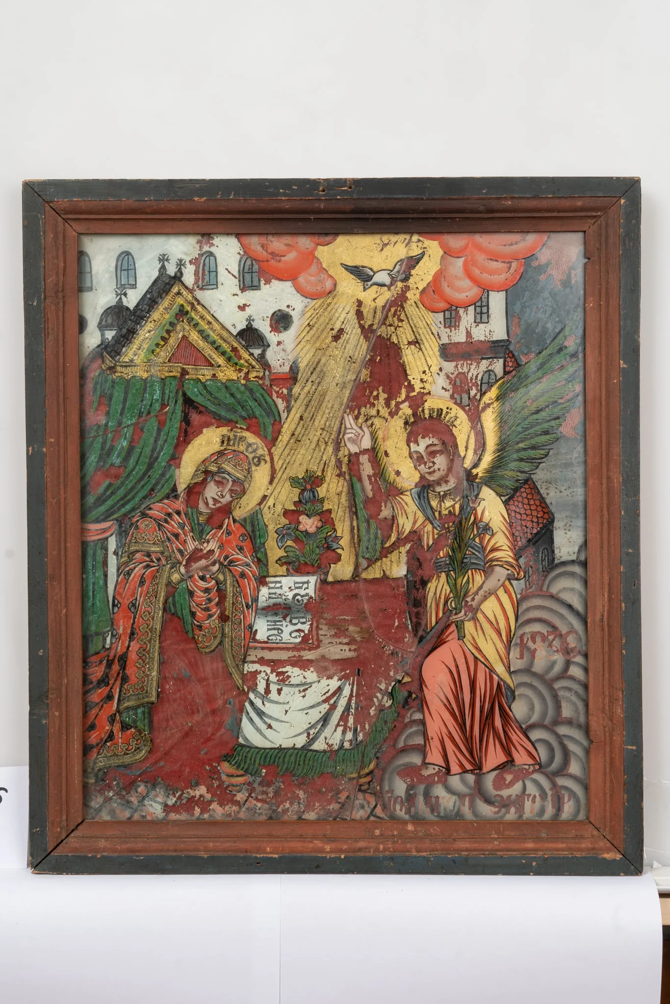 Fecioara Maria, dispusă în partea stângă a compoziției, este pictată în genunchi, într-o atitudine plină de evlavie. Arhanghelul Gavriil, este pictat în picioare, în partea dreaptă a scenei, ținând un crin în mâna stângă, iar cu dreapta binecuvinteză. Duhul Sfânt, în chip de porumbel, trimite raze din slava cerului spre Maica Domnului. Între cei doi sfinți e o masă pe care e pictată cartea sfântă deschisă, iar în spate, un ghiveci cu flori. Pe carte apare scrisă tema icoanei: "Buna Vestire". În spatele Maicii Domnului e reprezentat un baldachin cu draperii verzi. În fundal se profilează o clădire cu mai multe ferestre. Cromatica icoanei se compune din tonuri de portocaliu, verde, albastru, galben, alb, gri. Rama icoanei e profilată, bicromă (latura interioară roșie, iar cea exterioară maronie) și e formată din îmbinarea a patru baghete de lemn. Sticla e spartă în mai multe fragmente., detail