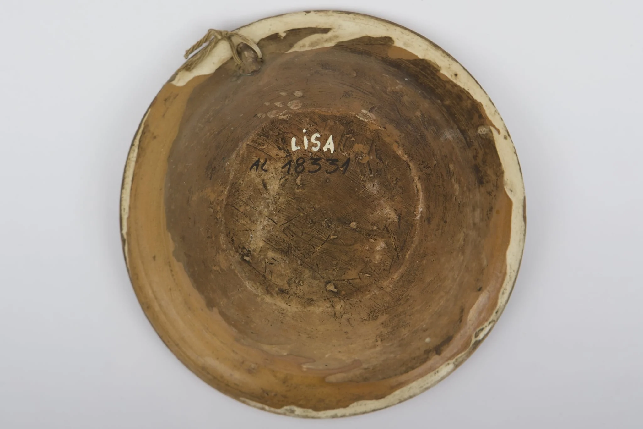 Vas ceramic smălțuit la interior, de formă tronconică, cu fundul plat, pereții ridicați și marginea evazată. Farfuria prezintă decor geometrizant și fitomorf stilizat. Pe fundul vasului, peste stratul crem de angobă, au fost realizate patru flori maro, cu mijlocul verde și albastru, fiind mărginite de patru grupuri a câte nouă puncte verzi și albastre (două câte două, în diagonală). Cel de-al doilea registru pictural a fost realizat marginal, pe buza piesei; fiind încadrat între două linii circulare drepte un șir de „V-uri” succesive. Farfuria era folosită în gospodărie pentru decorarea interioarelor sau servirea hranei. Prezintă uzură funcțională: Cromatică: fond: cărămiziu; crem; motive: maro; verde; albastru., detail
