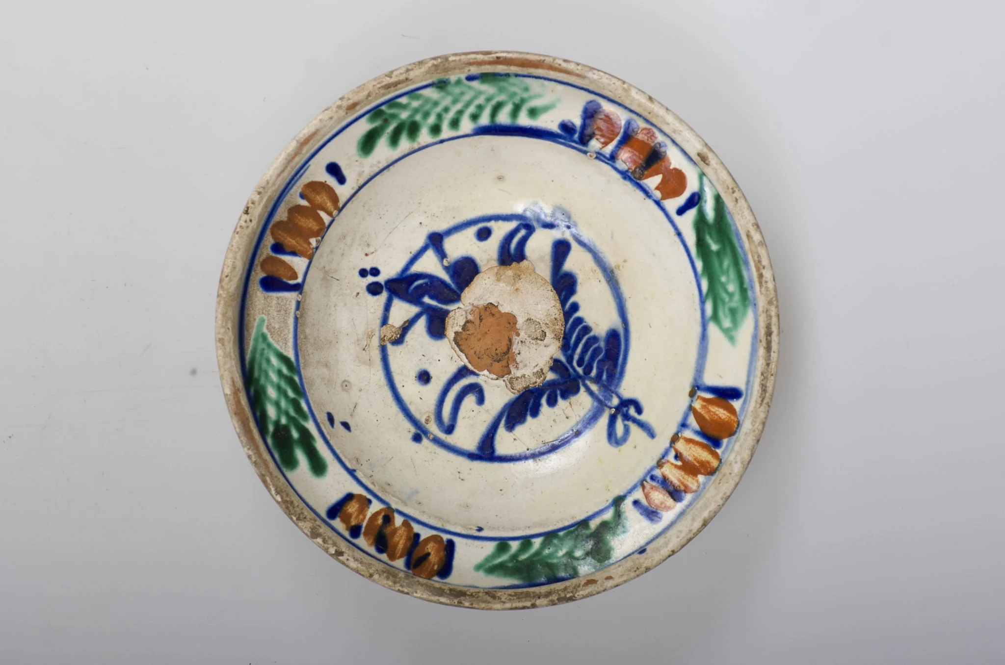 Vas de formă tronconică adâncit, smălțuit în interior cu buză profilată spre exterior. Este decorat în interior cu motive vegetale și florale (motivul brăduțului) dispuse într-un registru circular pictat pe în zona diametrului maxim al vasului. Cromatică: fond cărămiziu (exterior) cu scurgeri de smalț alb spre baza vasului; fond crem (interior); albastru; maro; verde; galben., detail