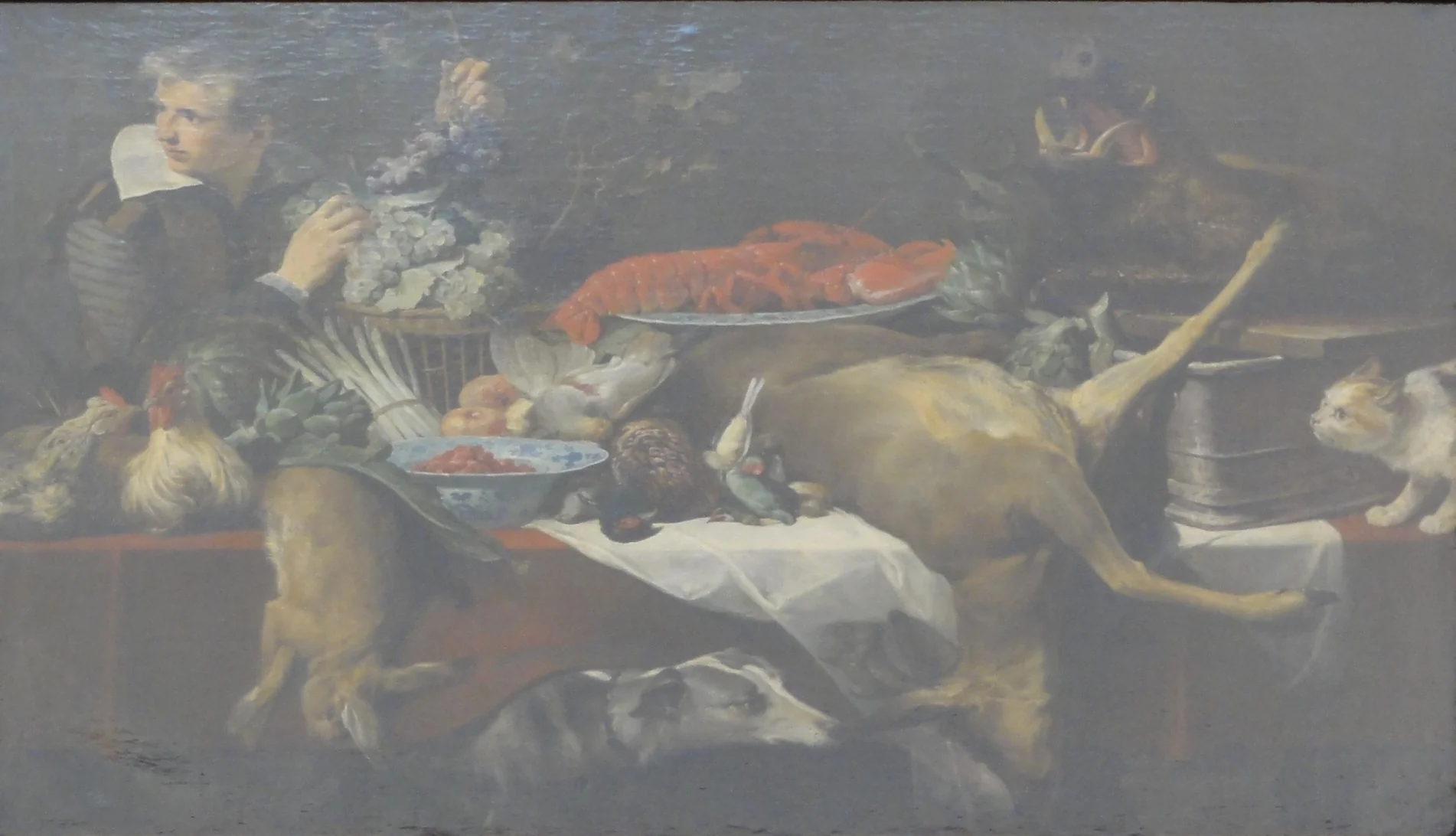 Kitchen scene with game and vegetables, with a serving boy holding a bunch of grapes, detail