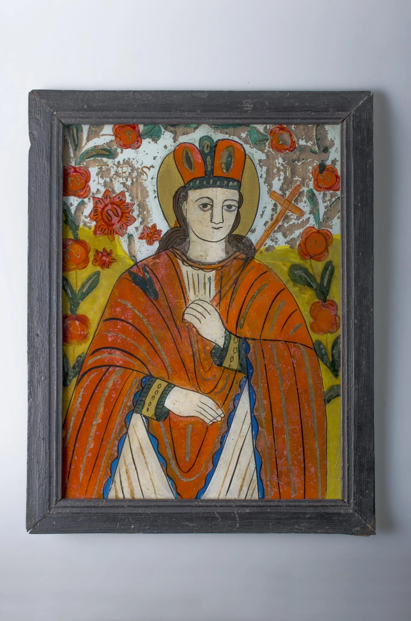 Icoana este pictată pe sticlă, având forma dreptunghiulară. Tema: Sfânta Paraschiva este reprezentată tânără, în veșmântul călugăresc al Sfintelor Cuvioase, purtând în mâna dreaptă crucea și în mâna stângă ramura de palmier. Pe fundalul galben și albastru avem două decoruri vegetale (lujeri cu flori) care completează compoziția. Cromatica: roșu; alb; negru; albastru; verde; galben. Pe spate icoana are o întăritură din lemn pentru protecția sticlei și o agățătoare din sârmă., detail