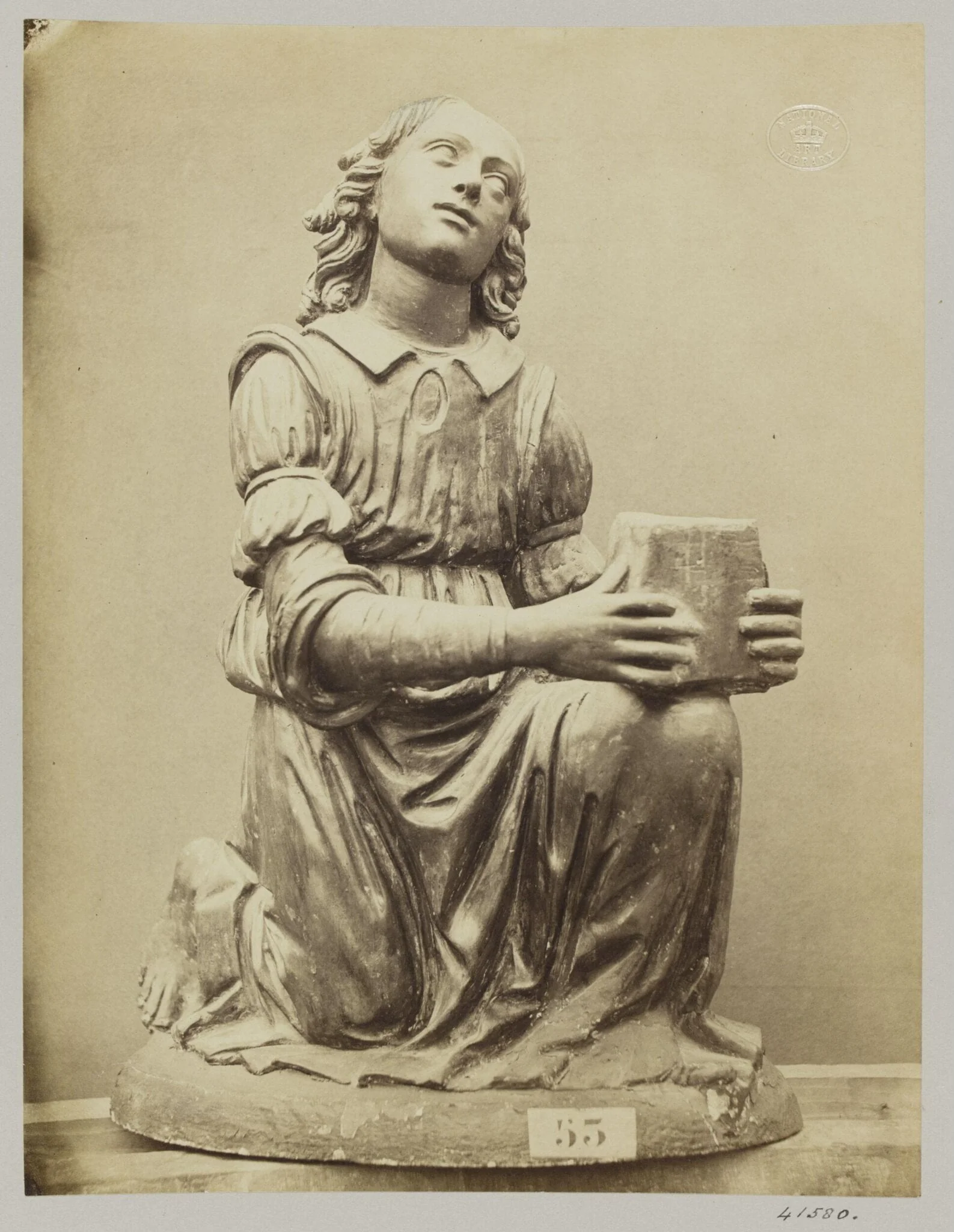 Figure of an angel on her knees in red terra cotta, detail