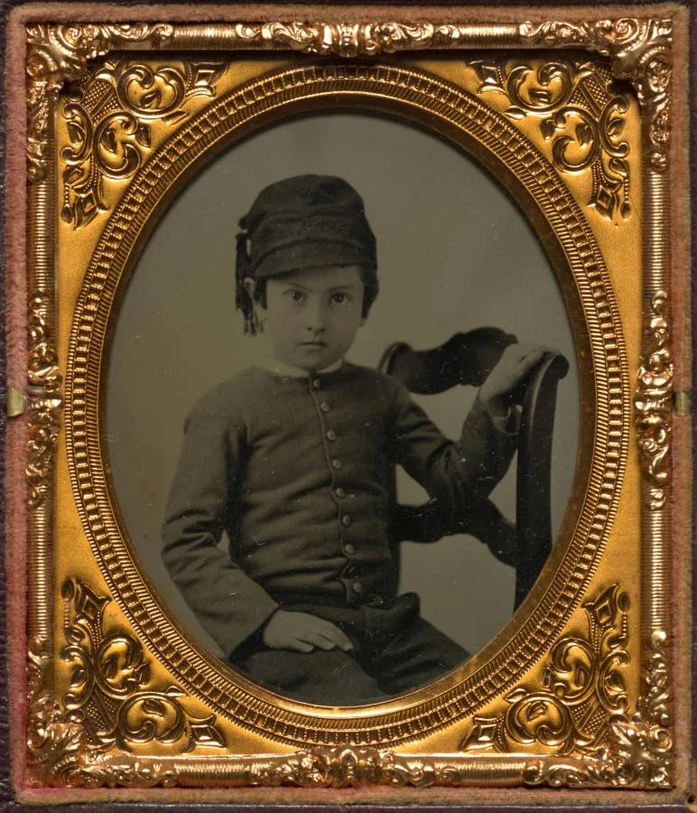 Seated boy in tasseled cap, detail