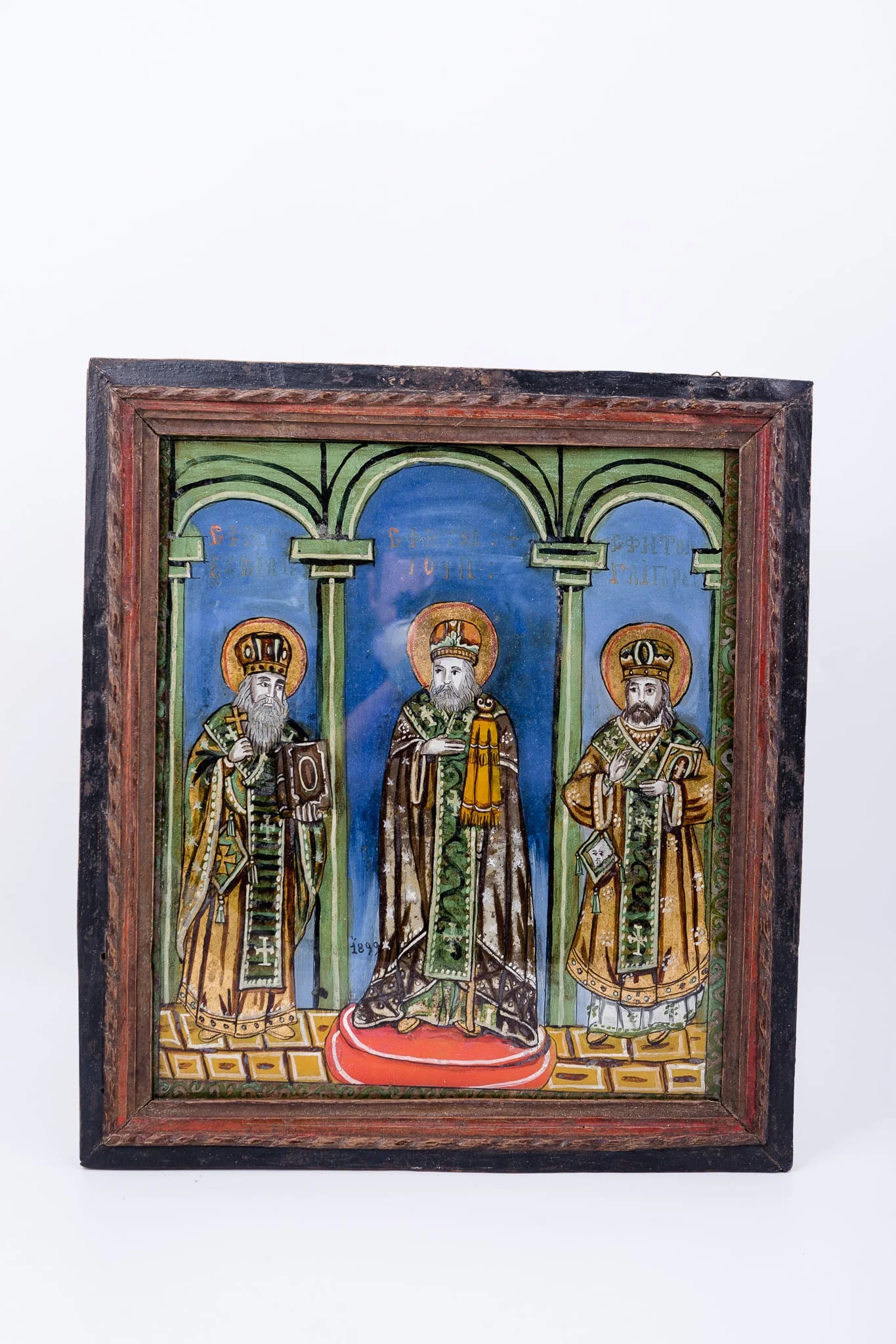 Cei Trei Sfinți Ierarhi Vasile cel Mare, Grigorie de Dumnezeu Cuvântătorul și Ioan Gură-de-Aur slujesc și săvârșesc Sfânta Liturghie împreună. Sunt înveșmântați în veșminte liturgice: sacos, felon și epitrahil verde, brun-ocru, kaki, brun-bronziu cu câte patru cruci pe mijlocul patrafirului. Sfântul Vasile cel Mare binecuvântează cu crucea în mâna dreaptă și ține în mâna stângă Sfânta Evanghelie. Sfântul Ioan Gură-de-Aur este în mijloc, așezat cu picioarele pe o pernă rotundă roșie, are mâna dreaptă lipită la piept, în semn de evlavie și cu mâna stângă ține cârja arhierească, Sfântul Grigorie binecuvântează cu mâna dreaptă și ține în mâna stângă Sfânta Evanghelie. Fondul este albastru ceruleum în registrul superior, în registrul inferior este un caroiaj brun-ocru-galben chihlimbar. Cromatica este armonioasă și săracă în nuanțe: verde smarald, absint, kaki, alb, roșu vermillon, albastru, alb, negru. Este o icoană specifică picturii de Valea Sebeșului, cu un desen fin cu conturul negru și cromatica pastelată. Inscripția din româno-chirilică se traduce Sfântul Vasile Sfântul Ioan Sfântul Grigorie., detail