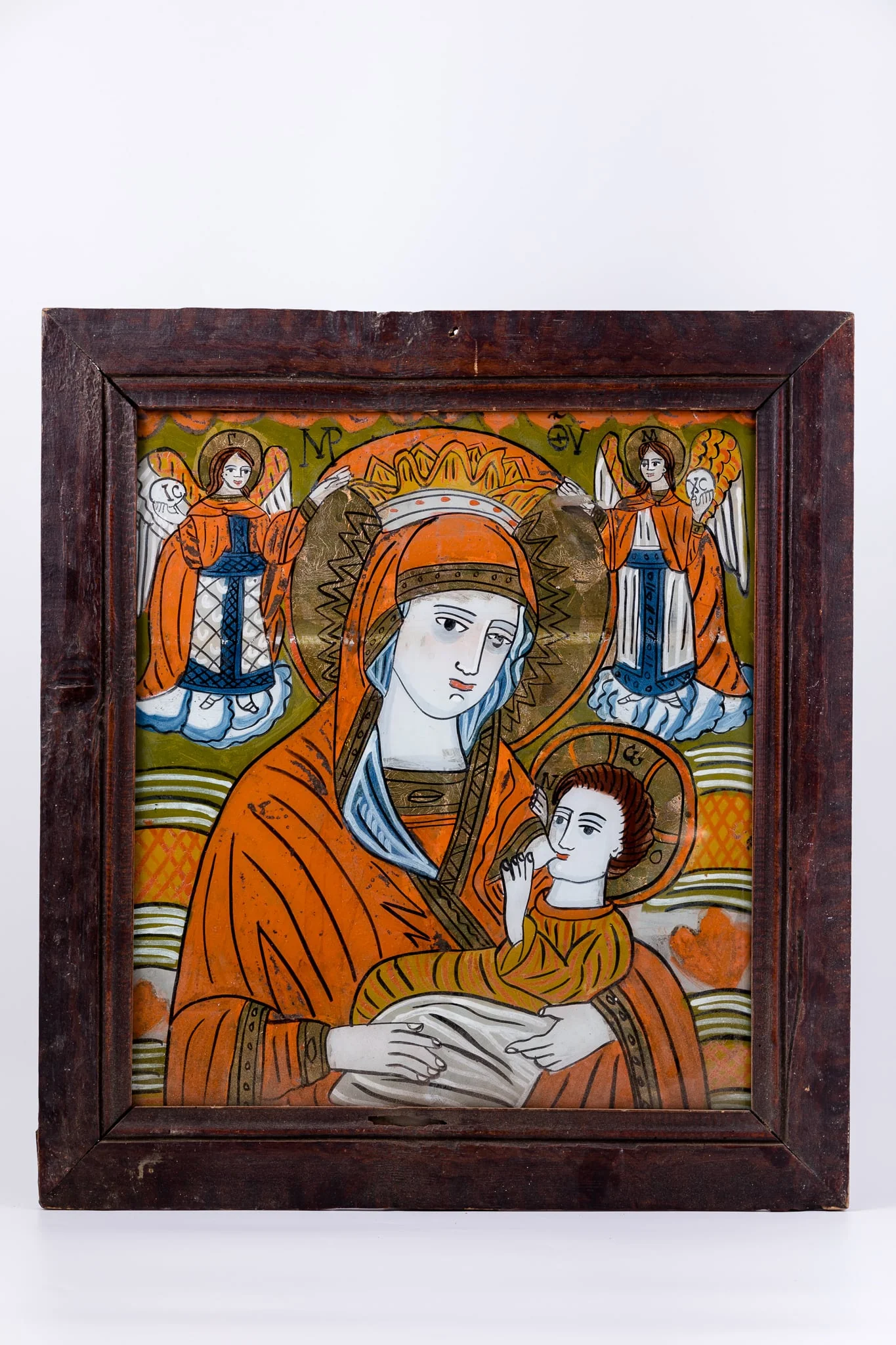 Maica Domnului ține în brațe Pruncul Iisus Hristos, pe care Îl alăptează, din sânul stâng, din dreptul inimii. Pruncul Iisus Hristos ține duios sânul cu ambele mânuțe. Maica Domnului este înveșmântată în mantie cu maforion roșu vermillon și sacos albastru dungat, asemenea unei ii cu gulerașul dantelat, poartă maforion, coroniță de împărăteasă și aureolă. Pruncul Iisus Hristos este înveșmântat în ocru-orange și gri-ivoriu, cu aureolă. În registrul superior, sunt Sfinții Arhangheli Mihail și Gavriil, ținând aureola Maicii Domnului cu mâinile. Sfinții Îngeri Arhangheli au picioarele pe mandorle de nouri alb-albaștri. Fondul icoanei este văzduhul de culoare verde văratic, împodobit cu elemente stilizat-florale, pete de roșu, ruje, în registrul superior. În registrul inferior, este un câmp luminos de verde-orange și galben-ocru. Cromatica este vie, senină și luminoasă: roșu vermillon, alb, albastru cobalt și bleu ciel, verde văratic, mușchi de pădure, verde brad, galben-ocru, alb, negru. Inscripția din româno-chirilică se traduce MP IC XC Maica Domnului Iisus Hristos. Este o icoană de Țara Oltului., detail