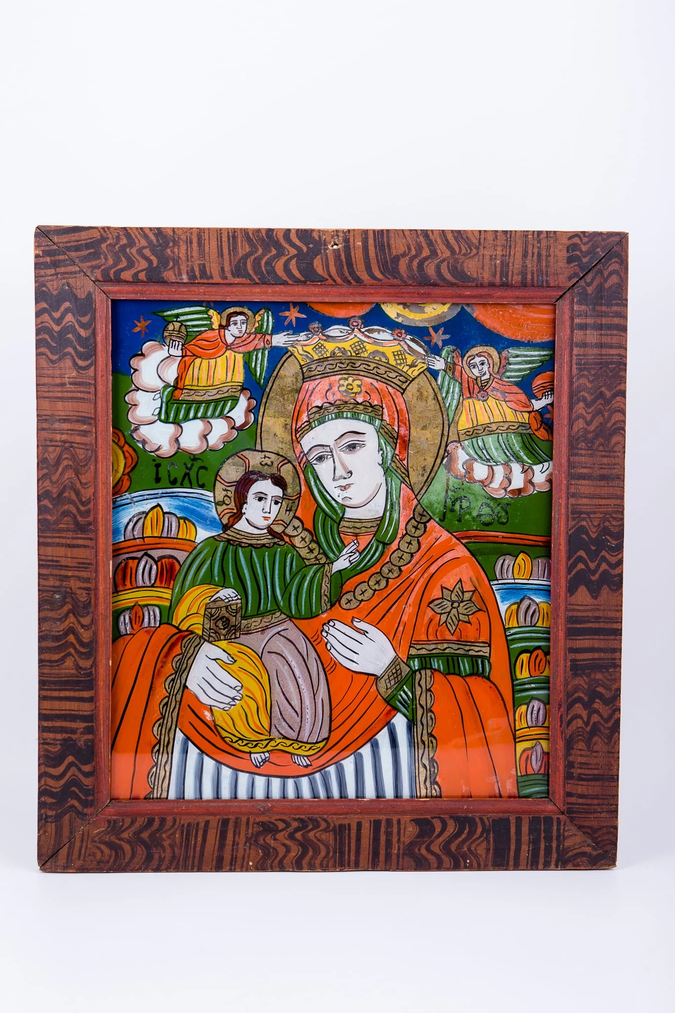 Maica Domnului Împărăteasă a Cerurilor, ține Pruncul Iisus Hristos, în brațe. Maica Domnului este îmbrăcată cu mantie cu maforion roșu vermillon, cu interiorul căptușit cu verde închis și albastru dungat cu alb. Poartă aureolă, coroniță de împărăteasă și salbă aurie din bănuți. Pruncul Iisus Hristos este îmbrăcat cu brun și verde și are aureolă și Sfânta Evanghelie închisă în mâna dreaptă și binecuvântează cu mâna stângă. În registrul superior sunt ocrotitori și păzitori Sfinții Arhangheli Mihail și Gavriil, cu mâinile atingând coronița Maicii Domnului Împărătese. Cromatica este armonioasă, caldă și luminoasă: roșu vermillon, verde spanac-avocado, galben-chihlimbar-ocru, albastru ceruleum bleu-ciel, brun, gri, alb, negru. Inscripția din româno-chirilică se traduce Maica Domnului MP Iisus Hristos IC XC. Icoana este de Șcheii Brașovului, Țara Oltului., detail