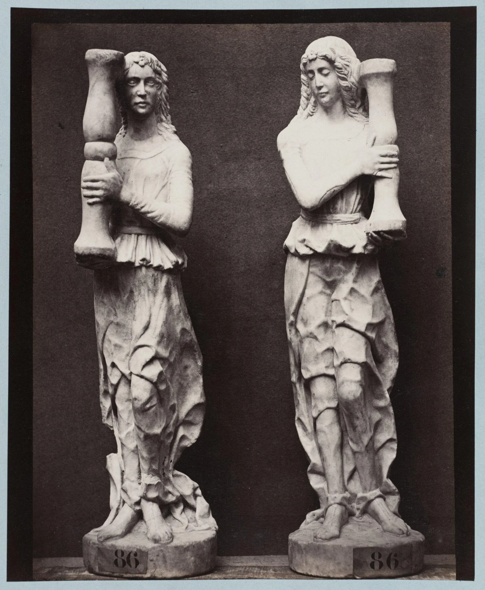 Marble statue of two angels holding torch bearers, detail