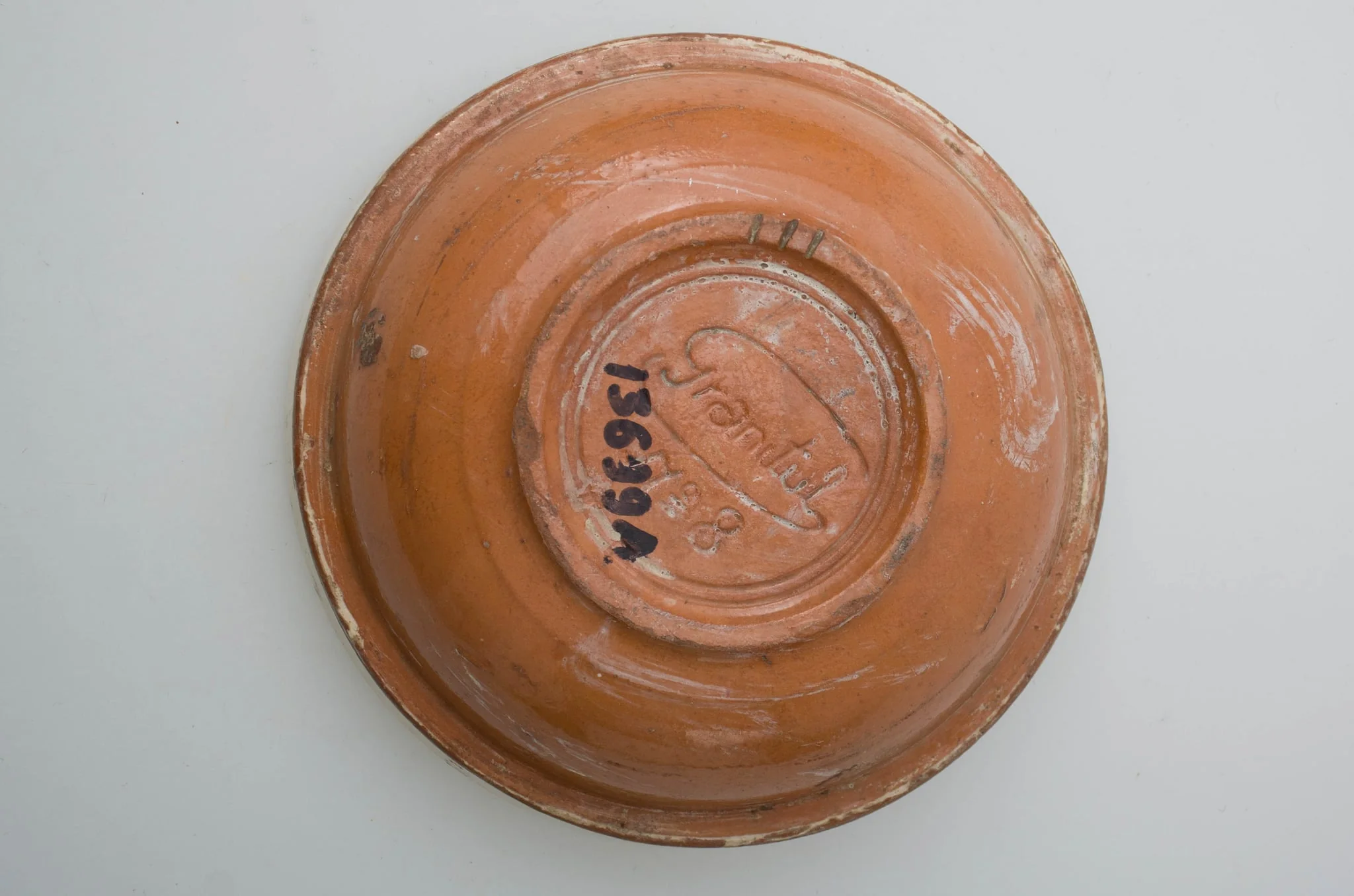 Vas ceramic smălțuit, de formă circulară cu profil tronconic, având pereții ușor evazați, baza plată și buza circulară. Decorat cu motive vegetal-florale și cordiforme pe fundul vasului (două rânduri de frunze, o lalea și o inimă), pictate cu pensula. Fundul vasului este delimitat de pereți printr-o linie subțire, circulară. Gura este pictată în alb și la exterior.Pe fundul vasului găsim marca Granitul No 8 și două cercuri concentrice, incizate. Cromatică: fond alb interior, cărămiziu și alb exterior; motive: albastru, cărămiziu, verde, maro., detail