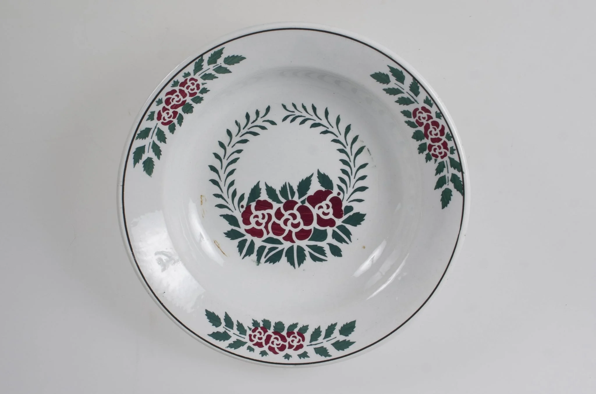 Vasul are formă tronconică, adâncită. Este decorat cu motive florale, vegetale și geometrice; are trei flori pe margine ce sunt delimitate de o linie; în centru este decorat cu un buchet format din trei trandafiri; pe fund are trei cercuri concentrice. Vasul este smălțuit interior-exterior. Cromatică: fond alb; motive: verde; roșu., detail