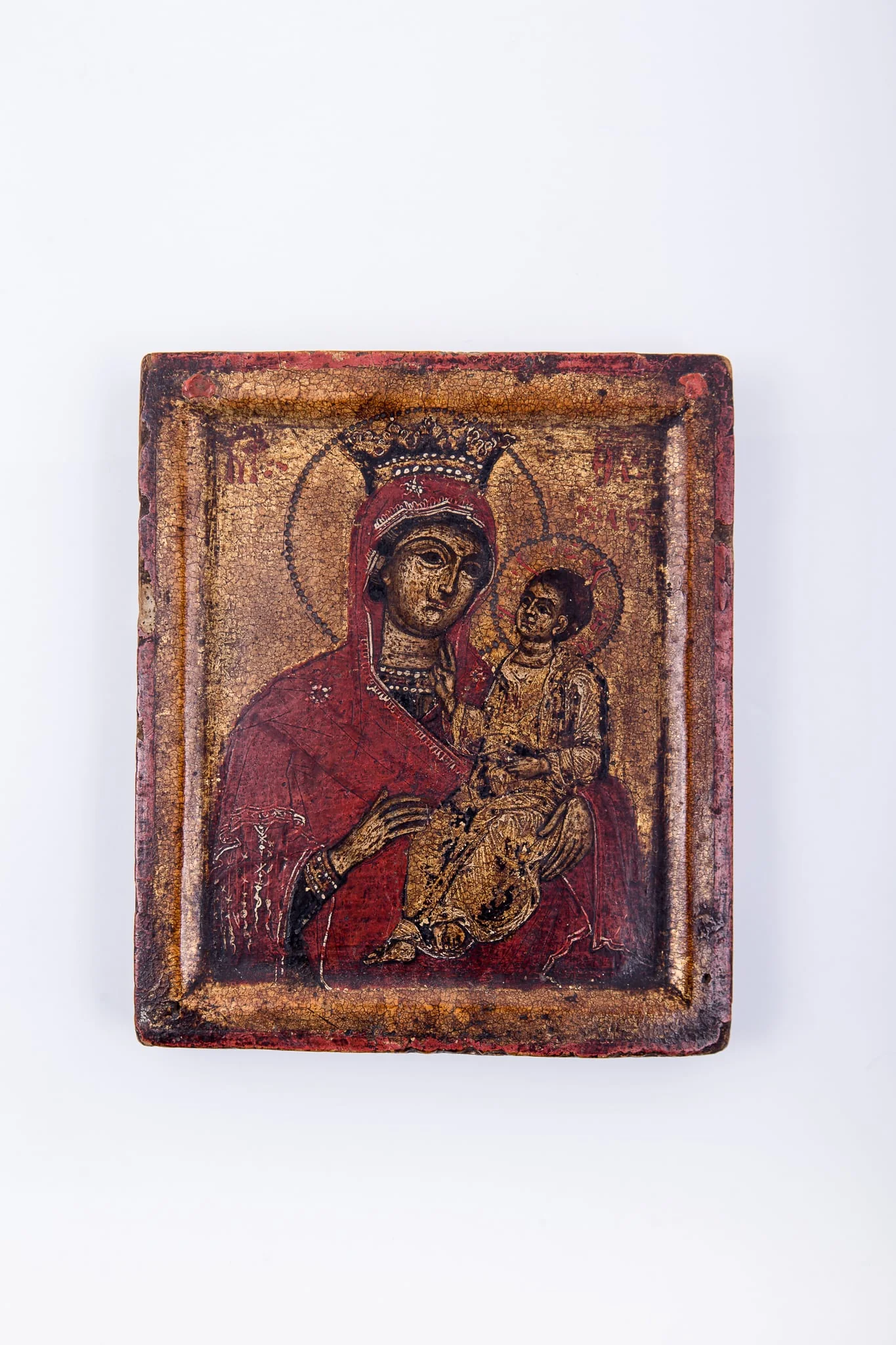 Maica Domnului ține în brațe Pruncul Iisus Hristos, înveșmântat în sacos bej-auriu. Pruncul arată cu mâna dreaptă înspre Maică arătându-ne-O și Maica arată către Prunc arătându-ni-L ca fiind calea, adevărul și viața, Este o icoană de tip Hodighitria. Maica Domnului este înveșmântată în mantie cu maforion roșu vermillon cu interiorul și ciupag negru, cu mărgețule albe, ca la coronița de Împărăteasă. Fondul icoanei este deschis-auriu-bronziu, luminos, dar foița aurie este deteriorată. Chipurile și trăsăturile fețelor sunt luminoase prin privire, atitudine și aureole. Cromatica este caldă și luminoasă: roșu-vermillon, galben-ocru, brun, bej, negru. Rama icoanei este realizată din aceeași bucată de lemn cu icoana însăși, este reliefat-sculpturată, basorelierf crestat, realizându-se o trecere ușoară de la icoană la ramă. Inscripția din româno-chirilică se traduce IC XC MP Iisus Hristos Maica Domnului., detail