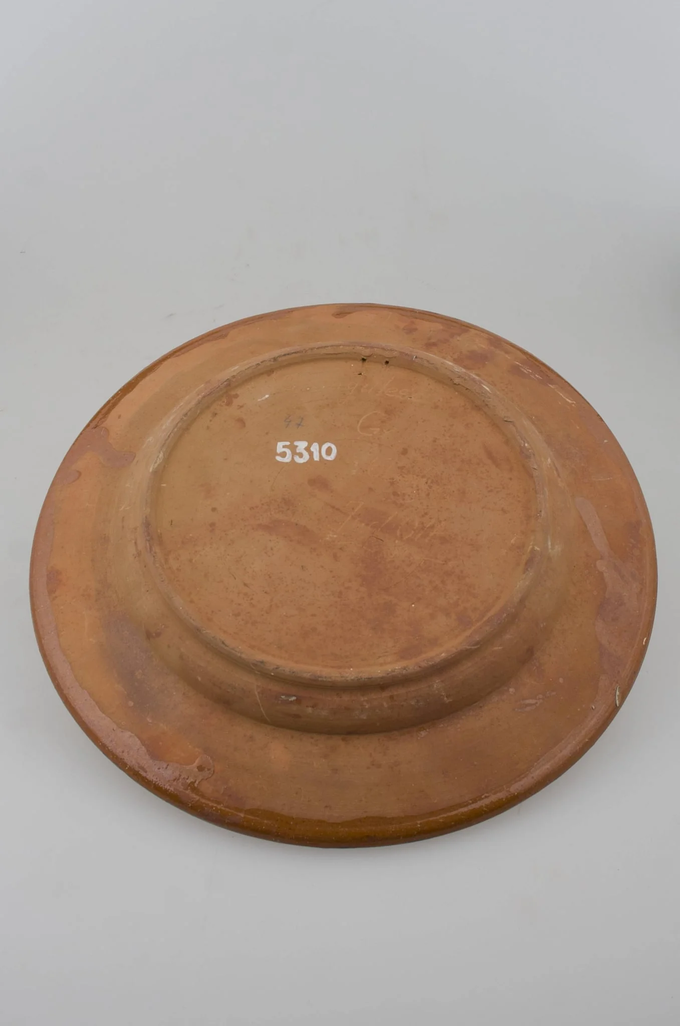 Blid tronconic cu fund plat, margine puțin ridicată și buza ușor oblică. Decor cu motive aviforme și florale: cocoș pe centru și o floare; pe margine, circular, motive geometrice (semicercuri, liniare, punctate, zig-zag). Cromatică: fond: cărămiziu; motive: maro; verde; alb; galben., detail