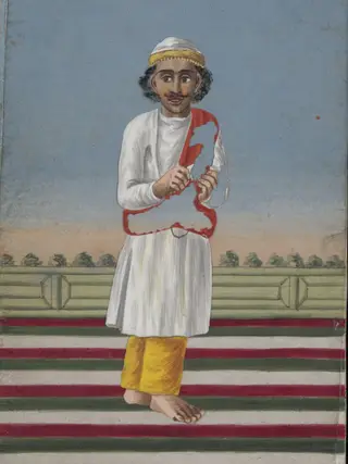 A Box covered and lined with brocade containing a card painted with a face, and with a verandah covered with a striped rug; also twelve mica overlays depicting dancers and musicians.