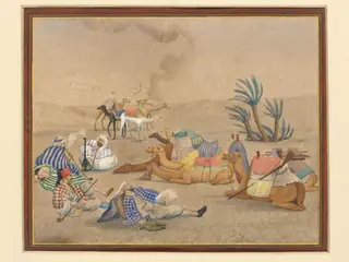 A caravan with camels resting at an oasis in the desert.