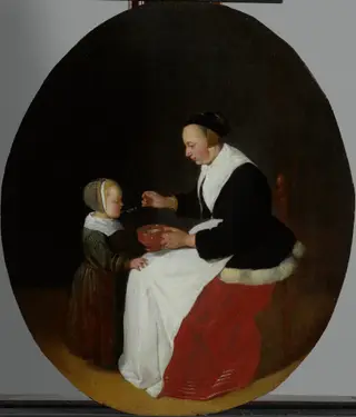 A mother feeding porridge to her child