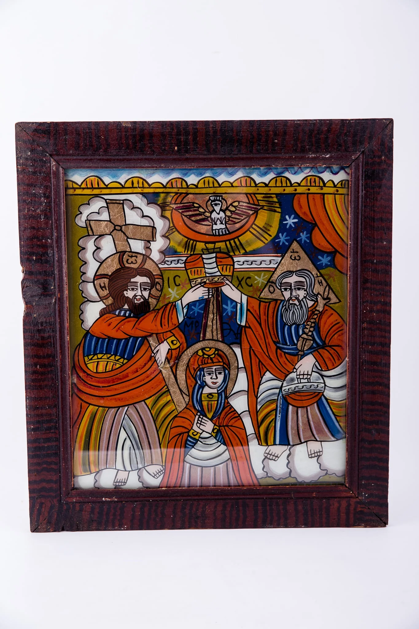 Dumnezeu Tatăl, Fiul Iisus Hristos așează dimpreună coroana de împărăteasă pe capul Maicii Domnului, iar din cerurile deschise se pogoară Sfântul Duh, printr-un porumbel, pe o rază luminoasă de soare. Compoziția se împarte simetric și echilibrat în patru părți, asemenea unei cruci. Fiul - Tatăl; Sfântul Duh - Maica Domnului. Maica Domnului are înălțimea mică a unei fetițe, fiind aleasă dintre oameni. Dumnezeu-Fiul are în mâna dreaptă Crucea, iar Dumnezeu-Tatăl are globul pământesc. Maica Domnului are mâinile împreunate în rugăciune și ascultare, smerenie și primire de bunăvoie. Sunt înveșmântați în roșu vermillon-galben-albastru. În registrul îndepărtat superior este cerul albastru cu stele albe, iar în registrul inferior sunt nori albi, toată narațiunea desfășurându-se în Împărăția Cerurilor, Maica Domnului fiind ridicată de pe pământ - Adormirea Maicii Domnului. În registrul superior, tematica iconografică este încadrată de un segment decorativ, geometrizant, asemenea unor colțișori de dantelărie. Inscripția în chirilică se traduce ICXC MP Iisus Hristos Maica Domnului. Cromatică: roșu vermillon, galben, albastru, alb. Icoana ste din Țara Oltului, Șcheii Brașovului., detail