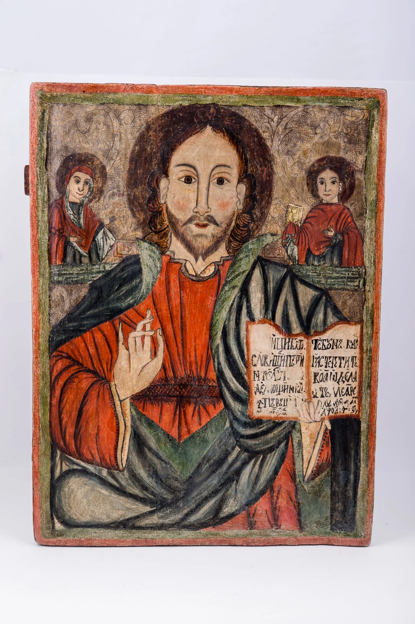 Deisis este o tematică fundamentală din iconografia bizantină, reprezentându-L pe Domnul Iisus Hristos în ipostasul de Mare Judecător, fiind Împărat, având în dreapta pe Maica Domnului și în stânga pe Sfântul Ioan Botezătorul și Înaintemergătorul Domnului. Această tematică este nucleul Judecății de Apoi. Iisus Hristos este înveșmântat în veșminte sacos și omofor albastre-verzi, cu aureolă. Are în mâna stângă Sfânta Evanghelie deschisă și cu mâna dreaptă binecuvântează. În registrul superior îndepărtat este fondul albastru brun-bej și Maica Domnului în semiprofil, în dreapta Mântuitorului și Sfântul Apostol și Evanghelist Ioan Teologul cu Sfânta Evanghelie închisă în mâna dreaptă, în partea stângă tronului Mântuitorului Iisus Hristos. Cromatica este armonioasă: roșu sângeriu, verde, olive, cafeniu, brun, ocru, bej, negru. Inscripția din româno-chirilică se traduce IC XC Iisus Hristos. Datarea se traduce din româno-chirilică: 17 februarie 1774. Icoana este atribită lui Petre Diacul din Preluca, Maramureș. Este icoană de iconostas. Ceea ce este inedit la această icoană, pe lângă toată frumusețea desenului, cromaticii, compoziției, trăsăturilor expresive, este și faptul că în locul Sfântului Ioan Botezătorul, din Deisis, este Sfântul Apostol și Evanghelist Ioan Teologul, numit Teologul Iubirii. Această dimpreunare a Mântuitorului Iisus Hristos cu Maica Domnului și cu Sfântul Ioan Teologul este și în icoana cu Răstignirea Domnului Iisus Hristos., detail
