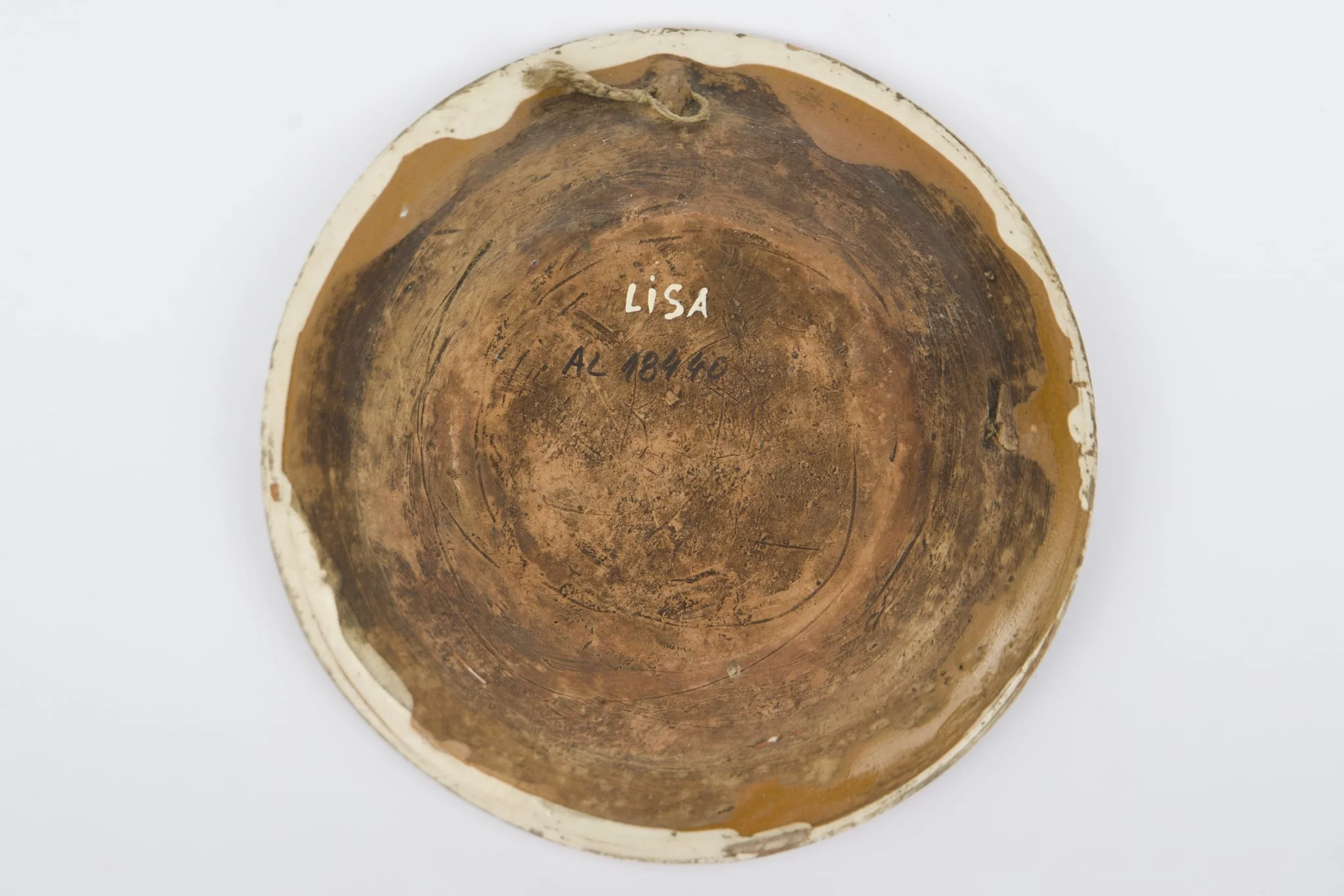 Recipient ceramic smălțuit la interior, de formă tronconică, cu baza plată, pereții înalți și marginea profilată. Peste stratul crem de angobă a fost pictat decorul geometrizant și fitomorf stilizat: Pe fundul vasului au fost realizate patru flori maro, cu mijlocul verde și albastru, fiind mărginite de patru grupuri de câte nouă puncte verzi și albastre (două câte două, în diagonală). Cel de-al doilea registru pictural a fost realizat marginal, pe buza piesei fiind încadrat între două linii circulare drepte un șir de „V-uri” succesive. Farfuria era folosită în gospodărie pentru decorarea interioarelor sau servirea hranei. Prezintă uzură funcțională: Cromatică: fond: cărămiziu; crem; motive: maro; verde; albastru., detail