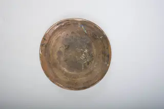 Blid de formă tronconică cu buza evazată și decor amplasat pe întreaga suprafață interioară. Blidul este decorat cu motive geometrice, linie, cerc, spirală, și motive vegetale stilizate. Cromatică: fond: crem; decor: cărămiziu; albastru; verde., 1850