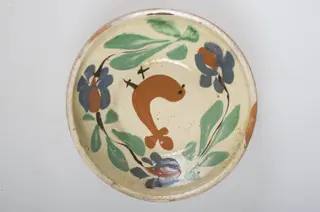 Blidul de formă tronconică este adânc, smălțuit (la interior). Vasul este ornamentat cu motive florale și avimorfe, cu buza înaltă, neornamentat și nesmălțuit la exterior. Cromatică: fond: maro-roșcat (exterior); alb (interior); decor: verde; maro; albastru; negru., 1850