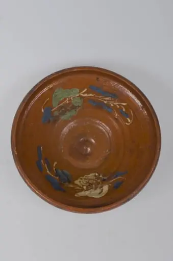 Castron de formă tronconică, adâncit. Marginea acestuia este foarte înaltă, fiind smălțuit în interior și exterior (buza). Pe margine este decorat cu motive vegetale și florale. Cromatică: fond cărămiziu; alb; verde; albastru. Castronul era folosit pentru depozitarea alimentelor.