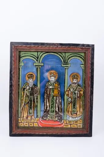 Cei Trei Sfinți Ierarhi Vasile cel Mare, Grigorie de Dumnezeu Cuvântătorul și Ioan Gură-de-Aur slujesc și săvârșesc Sfânta Liturghie împreună. Sunt înveșmântați în veșminte liturgice: sacos, felon și epitrahil verde, brun-ocru, kaki, brun-bronziu cu câte patru cruci pe mijlocul patrafirului. Sfântul Vasile cel Mare binecuvântează cu crucea în mâna dreaptă și ține în mâna stângă Sfânta Evanghelie. Sfântul Ioan Gură-de-Aur este în mijloc, așezat cu picioarele pe o pernă rotundă roșie, are mâna dreaptă lipită la piept, în semn de evlavie și cu mâna stângă ține cârja arhierească, Sfântul Grigorie binecuvântează cu mâna dreaptă și ține în mâna stângă Sfânta Evanghelie. Fondul este albastru ceruleum în registrul superior, în registrul inferior este un caroiaj brun-ocru-galben chihlimbar. Cromatica este armonioasă și săracă în nuanțe: verde smarald, absint, kaki, alb, roșu vermillon, albastru, alb, negru. Este o icoană specifică picturii de Valea Sebeșului, cu un desen fin cu conturul negru și cromatica pastelată. Inscripția din româno-chirilică se traduce Sfântul Vasile Sfântul Ioan Sfântul Grigorie.
