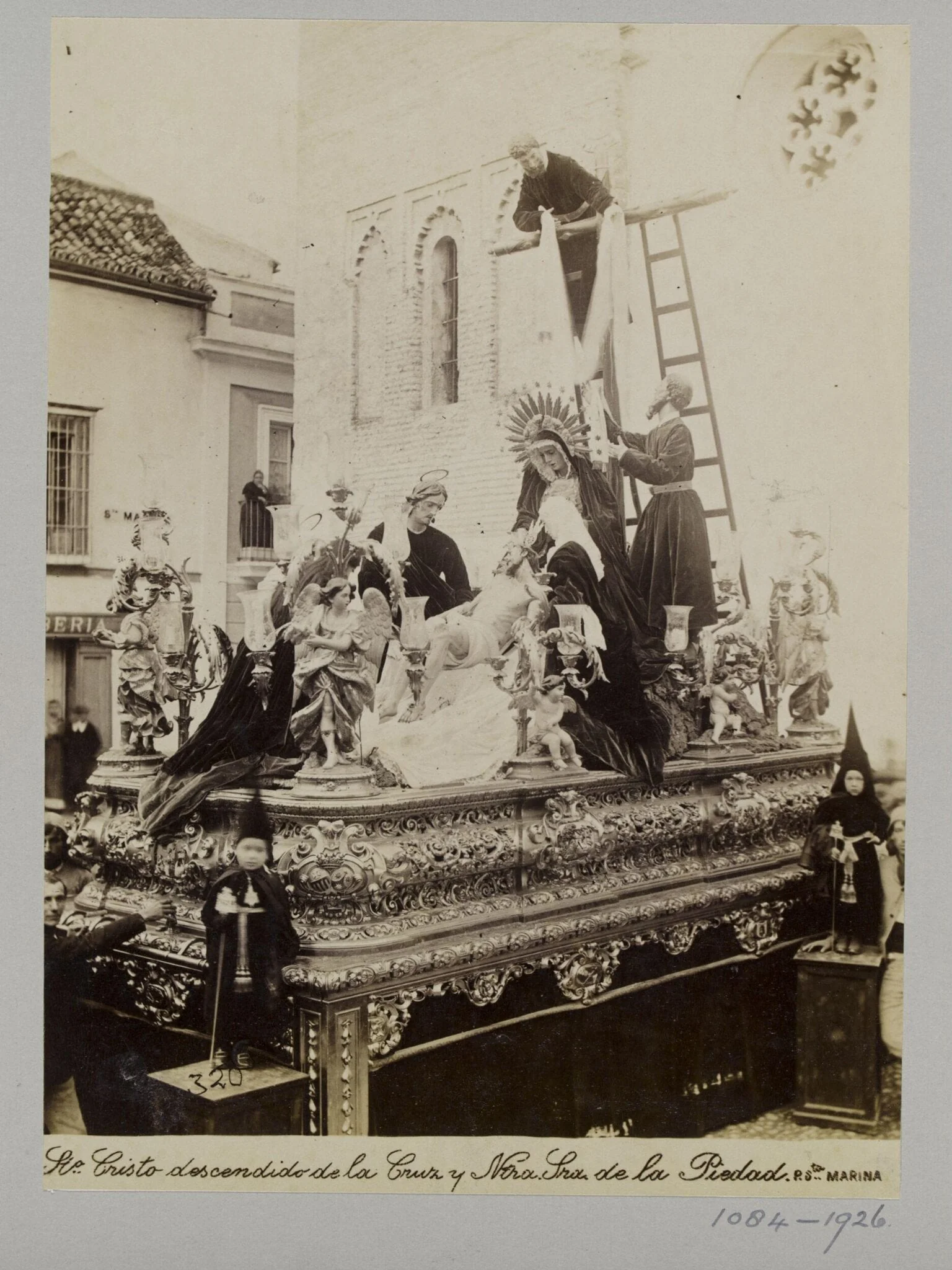 Processional statuary group belonging to the Fraternity of the Parish of Santa Marina, Seville, with children in special dress in the foreground, detail