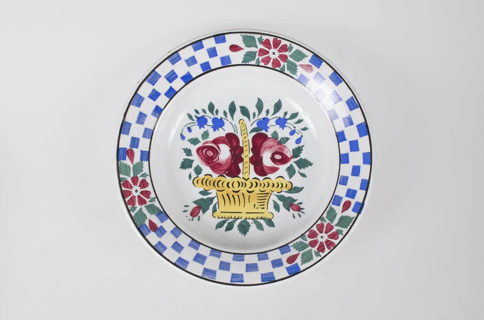 Vas de formă tronconică, adâncă. Pe fundul farfuriei se află un ornament format din: un coș de flori (trandafiri și clopoței). Pe marginea farfuriei între două cercuri concentrice apar trei flori despărțite de trei registre în formă de tablă de șah realizate din dreptunghiuri albastre. Cromatică: fond: alb; motive: galben; roșu; verde; albastru; negru., detail