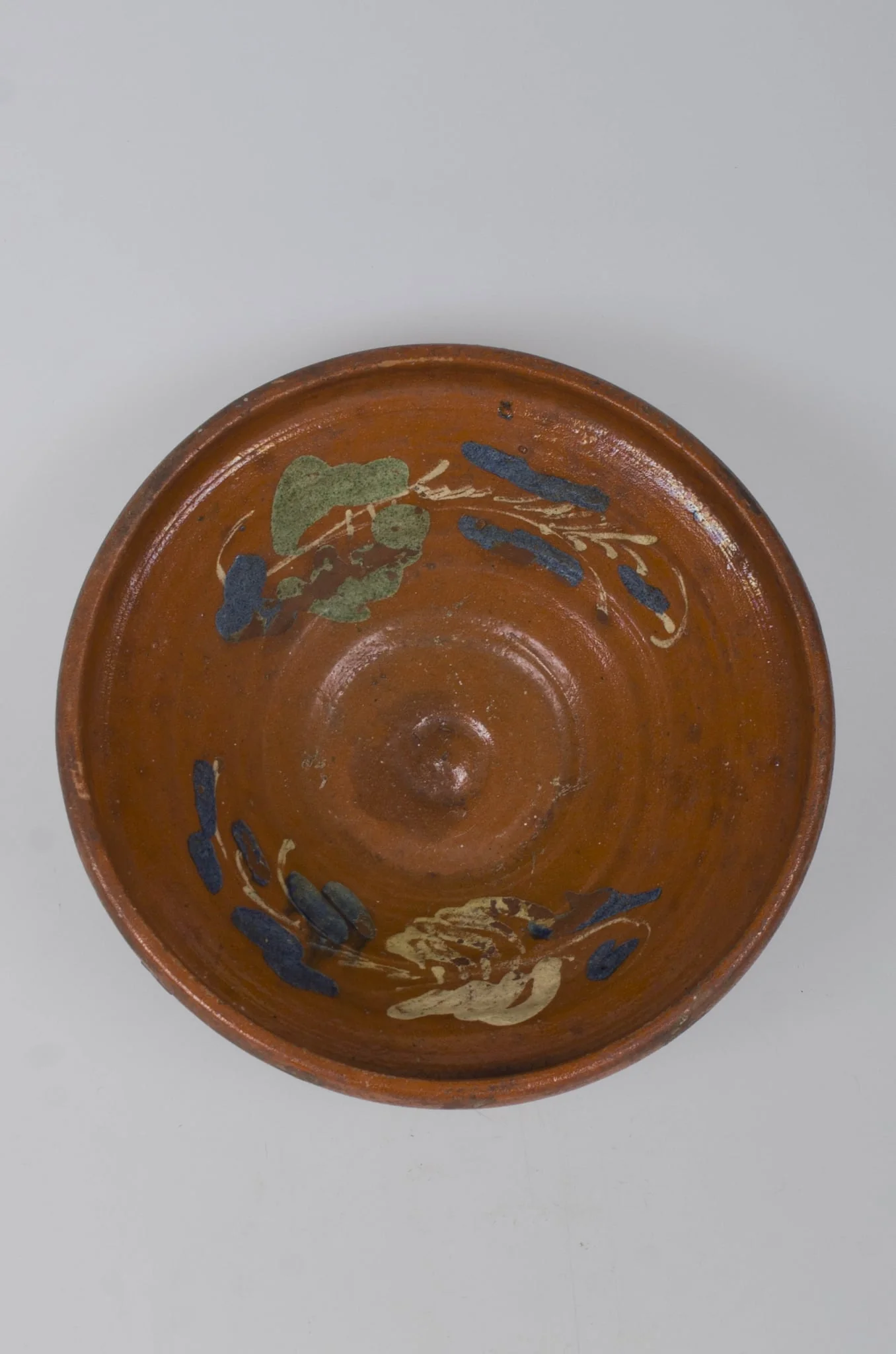 Castron de formă tronconică, adâncit. Marginea acestuia este foarte înaltă, fiind smălțuit în interior și exterior (buza). Pe margine este decorat cu motive vegetale și florale. Cromatică: fond cărămiziu; alb; verde; albastru. Castronul era folosit pentru depozitarea alimentelor., detail