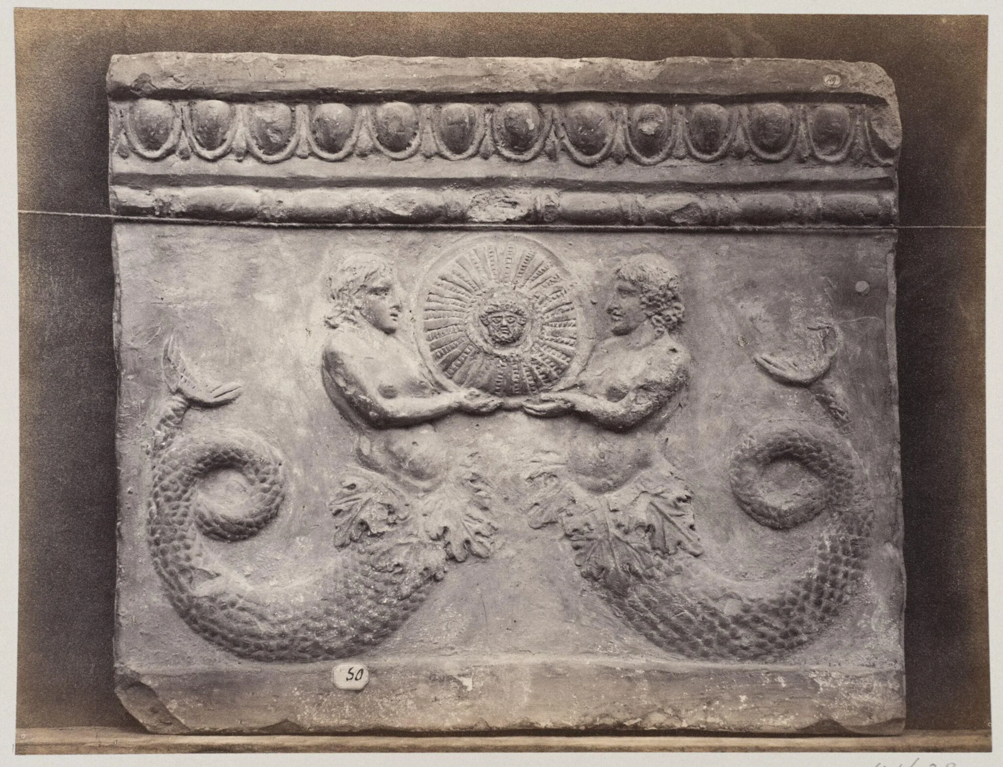 Bas-relief portion of frieze with tritons in terra cotta, detail