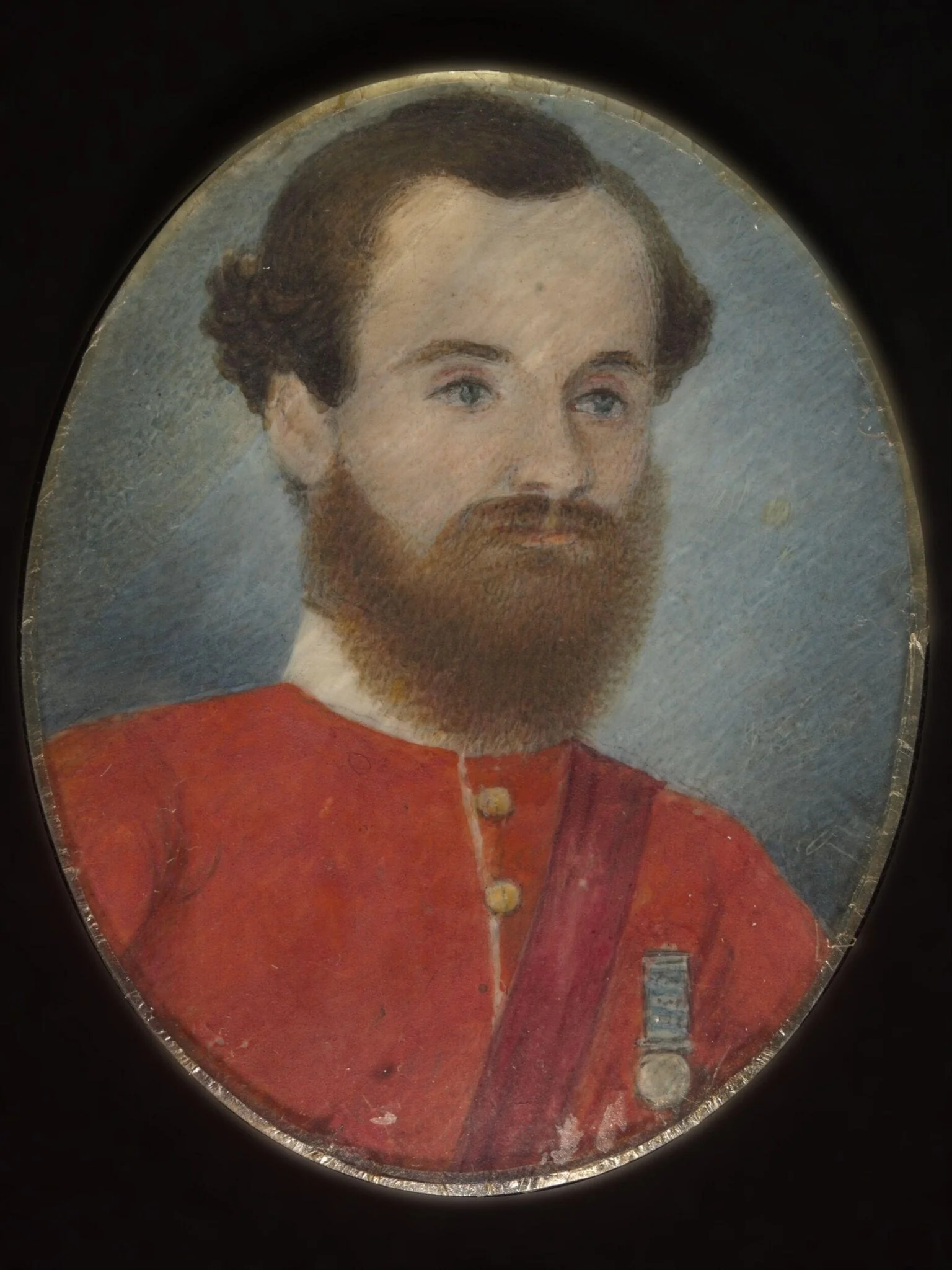 A European soldier in a red uniform wearing a medal., detail