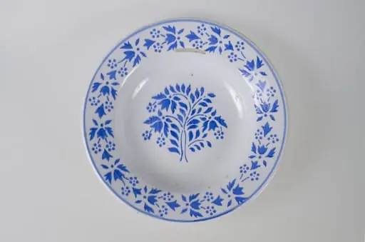 Farfuria are formă tronconică ușor adâncită. Pe buza vasului se identifică un registru decorativ floral, vegetal, continuu mărginit de o linie. Pe fund este o ștanță: o casă cu o pasăre pe acoperiș. Pe fundul vasului sunt două incizii în care este introdus șnurul folosit la agățarea vasului pe perete. Cromatică: fond: alb; motive: albastru.