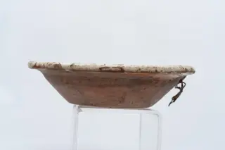 Farfurie adâncă, cu corp tronconic și buza mai îngustă și evazată; este acoperită pe fața interioară cu un strat de abgobă albă, peste care este pictat decorul format din pete neregulate de culoare maro și verde, realizate prin stropire cu pensula. Suprafața ornamentată a farfuriei este acoperită cu un strat de smalț transparent. Cromatica: alb, verde, maro., 1850