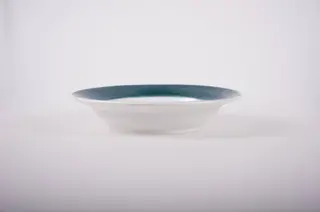 Farfurie de formă tronconică, adâncită; pe fund are găuri pentru agățare. În centru este decorată cu motive florale; marginea este pictată verde; pe fund are trei cercuri concentrice. Cromatică: fond: alb; motive: verde; vișiniu; albastru; galben., 1850