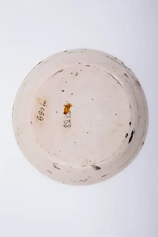 Farfurie plată, cu marginea îngustă și evazată spre interior. Pe marginea farfuriei sunt redate trei buchete de trandafiri roșii cu boboci și frunze. Grupurile florale sunt intercalate de trei boboci de trandafir. Decorul central reprezintă un buchet alcătuit dintr-un trandafir mare, înflorit și două fire de boboci de trandafiri. Cromatică: alb, roșu, verde.