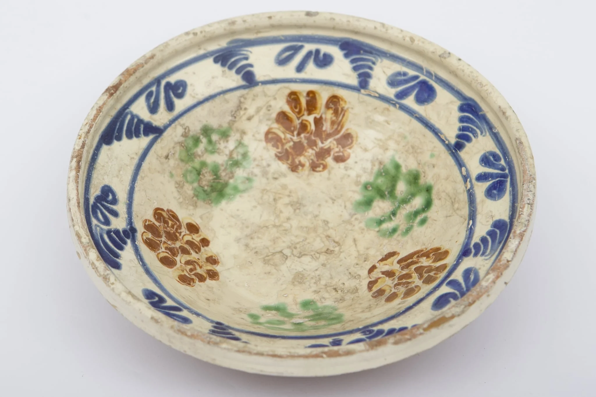 Vas ceramic de dimensiuni medii, smălțuit la interior, având formă tronconică. Blidul a fost decorat cu motive geometrizante și fitomorfe stilizate. Primul registru, dispus pe fundul piesei este format din șase flori verzi și maro, intercalate. Marginal, pe buza profilată a fost realizat cel de-al doilea registru, fiind trasate două linii circulare, care încadrează motive vegetale albastre, succesive. Blidul era folosit pentru servirea hranei. Prezintă uzură funcțională. Cromatică: fond: cărămiziu; crem; motive: albastru; maro; verde., detail