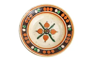 Formă tronconică; fond alb; culori: verde; roșu - cărămiziu; maro; În centrul farfuriei este amplasată o cruce în X de culoare verde, între brațele crucii sînt amplasate patru petale sub formă de inimă de culoare roșie - cărămiziu care sugerează o floare. Pe perete într-o bandă circulară de culoare maro sînt dispuse grupuri de puncte de culoare roșu - cărămiziu, albe și verzi alternînd cromatic. Sub buza vasului este amplasat un cerc de culoare cărămizie.