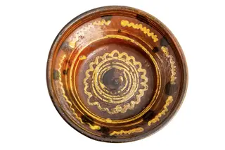 Formă tronconică; fond cărămiziu; culori: galben, verde, brun. În centru este amplasată o spirală de culoare galbenă trasată cu cornul înscrisă într-un val circular de culoare similară care sugerează un soare; pe perete strachinei sînt amplasate șase segmente de linie vălurită de culoare galbenă și pete de culoare brună.