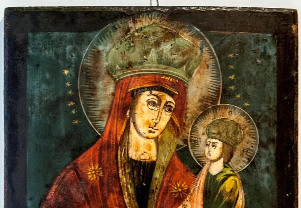 Maica Domnului cu Pruncul, tip derivat din Hodighitria(Călăuzitoarea), stil ce indică o școală rusească. Maria 3/4, ține Pruncul pe mâna stângă. Isus îi ține mâna dreaptă cu ambele mâini. Fecioara privește către Prunc cu cu o expresie de tristețe. Înveșmântată cu stolă albastră, cu blicuri de culoare mai deschisă, și decorațiune delicată la mâneci.Maforion roșu vișiniu, anticipând patimile.Pe margine decorație fină, la mânecă franjuri delicați. Pe frunte și pe umeri poartă stelele întreitei Feciorii, în formă de floare cu petale aciculare. Steaua de pe frunte este parțial acoperită de coroana împărătească de tip rusesc, închisă, mare. Aureola din raze alb galbene dispuse orizontal și încadrate de un cerc trasat cu un instrument. Isus poartă același tip de coroană, înconjurată de aureola cu raze, peste care au fost inscipționate însemnele nimbului cruciger. Chipul matur, sobru, trist, privind către Maica Sa. Fața rotundă, capul și mâinile de proporții mai mici în raport cu corpul.Înveșmântat cu un chiton verde cu blicuri galbene, peste care poartă, petrecut pe umărul drept un himation roșu orange cu blicuri alb aurii.Desculț. Nimburile sunt înconjurate de steluțe mici, aurii, dispuse pe fondul bleu închis la o mică distanță de linia de contur. Lângă umărul drept al Maicii apare o inscripție parțial șterasă, cu majuscule, în slavonă,.(SPOPUȘNIINÎ METȘA?). Chenar lat de culoare neagră, care este depășit de aura Fecioarei în partea de sus., by Hugo Kołłątaj