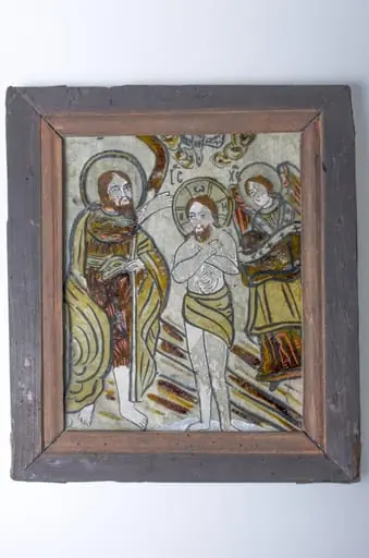 Icoana este pictată pe sticlă, având tema Botezului. Iisus se află în apa Iordanului fiind încadrat în stânga de Sfântul Ioan Botezatorul iar în dreapta de un înger cu năframa în mâini. Deasupra lui Hristos, în nori, este redat Sfântul Duh în chip de porumbel, iar dedesubt sunt înscrise în grafie chirilică prescurtarea numelui lui Iisus: „ICXC”. Pe verso-ul ramei sunt prinse scânduri subțiri din lemn pentru protecția icoanei. Cromatică: fond: gri; roșu; alb; negru; culoarea lemnului grunduit.