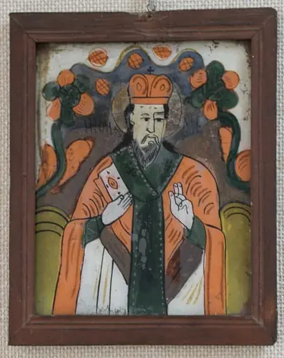 Icoana îl reprezintă pe Sf. Nicolae 3/4 în veșmânt de marea ierarh, cu mitră pe cap, într-un chenar din flori în partea de sus. Desenul este naiv, compoziția simplă, schematică. Sfântul, cu mitră pe cap și aureolă, binecuvintează cu stânga, zugravul a desenat tiparul fără să țină seama de faptul că urma să picteze "în oglindă".În dreapta ține Evanghelia.Părul și barba sunt negre, ceea ce nu corespunde reprezentării canonice a sfântului, dar caracterizează frecvent reprezentarea populară. În partea de sus este realizat un chenar din două flori cu frunze, unite printr-o linie vălurită împodobită cu boboci de floare.Câteva linii sugerează un relief colinar. Cromatica este variată, culori intense, creînd contraste(roșu cu verde).Câmpul este alb murdar. Rama este vopsită cu un roșu șters. Spatele este completat cu o lemn subțire de brad., by iconar zugrav