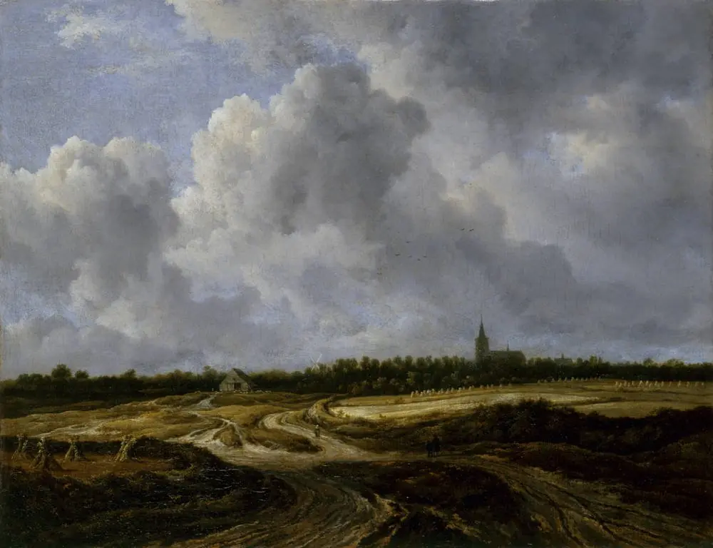 Extensive field landscape with a track and a church in the distance