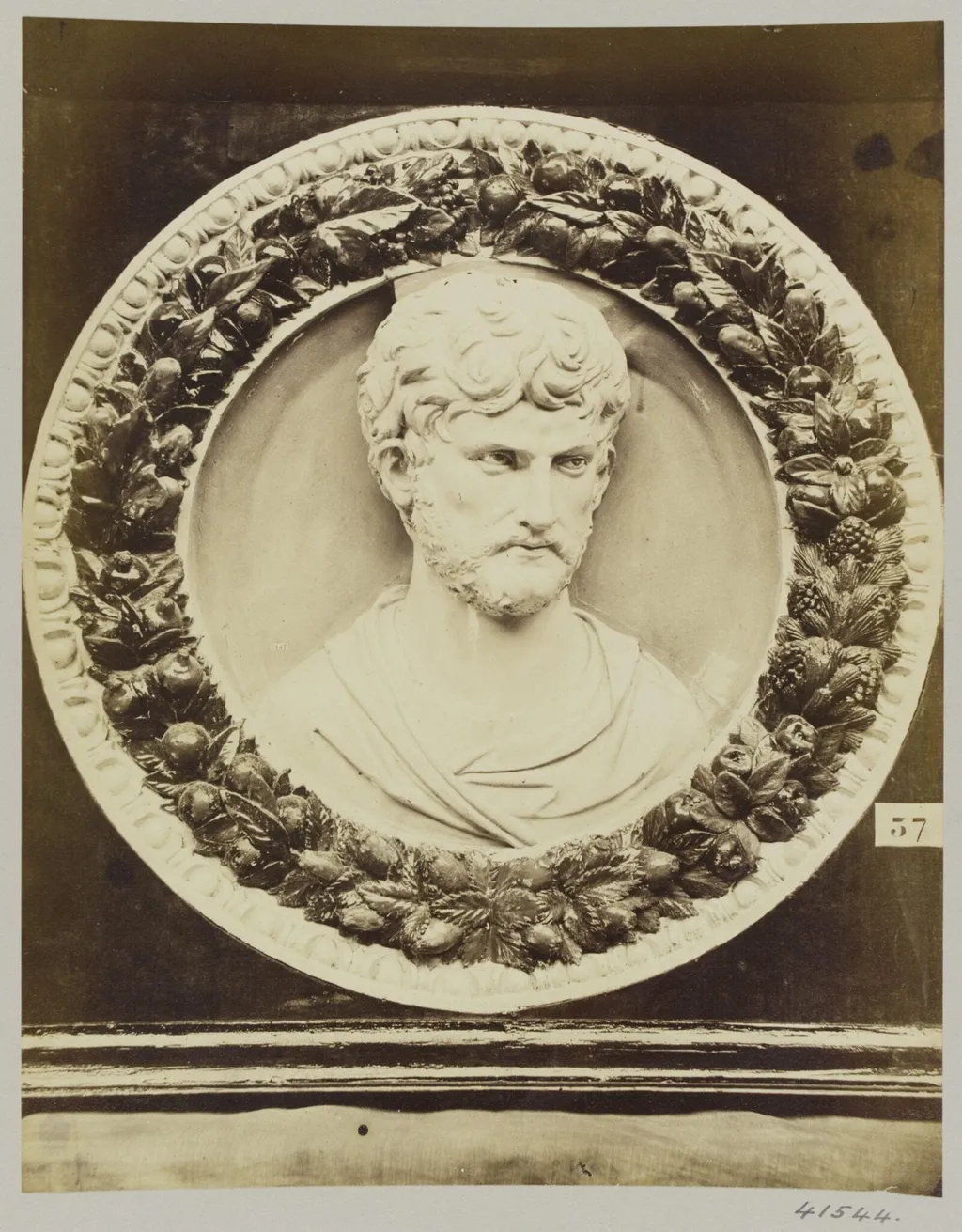 Circular bas-relief white portrait bust on blue ground surrounded by a garland of foliage and fruit in enamelled terra cotta, by Louise Laffon, photographic, 1864