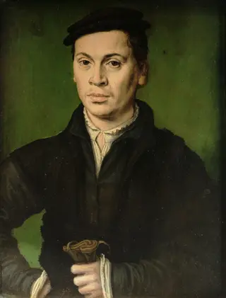 Man in black beret holding a pair of gloves