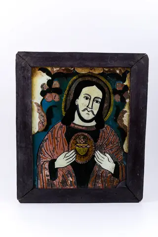 Mântuitorul Iisus Hristos este înveșmântat într-o tunică-sacos gri-antracit înspre negru și mantie roșie vermillon, având deschisă inima cu raze luminoase-aurii. Cu amândouă mâinile Își dăruiește inima aurită cu har. Are părul negru lung, lăsat pe umeri și aureolă galbenă. Fondul icoanei este cerul albastru ceruleum-regal, înconjurat de un chenar decorativ ivoriu-crem și întreaga compoziție iconografică este încadrată de un chenar decorativ fitomorf, format dintr-o ghirlandă de ruje - 2 ruje mari cu șase petale roșii-negre, cu formă de margarete. Cromatica este armonioasă și discret de luminoasă: roșu vermillon-roz, verde kaki, albastru ceruleum și regal, cobalt, brun cafeniu, galben-ocru-muștar, alb, negru. Icoana este rară din punctul de vedere al tematicii abordate - Iisus Hristos cu Inima, tematică cu influențe catolice și pictural-apusene. Icoana este din Nordul Transilvaniei, Nicula.