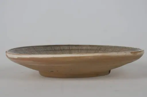 Vas ceramic smălțuit de mici dimensiuni, modelat la roata olarului, uscat, pictat, ars de două ori și smălțuit. Taierul prezintă o bază plată din care pornesc pereții foarte evazați/arcuiți cu buza ridicată. Decorul este dispus pe toată suprafața vasului, care în prealabil a fost angobat. Fundul vasului este nedecorat; în zona de demarcarea dintre fundul vasului și pereți un registru jirăvit, cuprins între două linii de culoare maro-roșcat. Un al doilea registru realizat din frunze de culoare verde, maro-roșcat și maro-închis. Marginea vasului a fost jirăvită, realizată cu „gaița”. Cromatica vasului este alb la interior și maro-deschis la exterior, iar cea a decorului pictat este maro-închis; verde; maro-roșcat; alb.