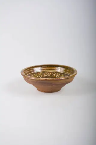 Recipient tronconic, cu gura mai largă decât baza, cu buza dreaptă și înaltă. Acesta este smălțuit doar la interior. Vasul este decorat prin pictare cu cornul, cu ornamente geometrice: spirală pe fund, linii circulare, linii vălurite și ”V”-uri înscrise pe pereți și decorații de tip val pe margine. Din punct de vedere al cromaticii, se observă un fond ocru la interior, cărămiziu la exterior, motivele fiind pictate cu alb., 1850