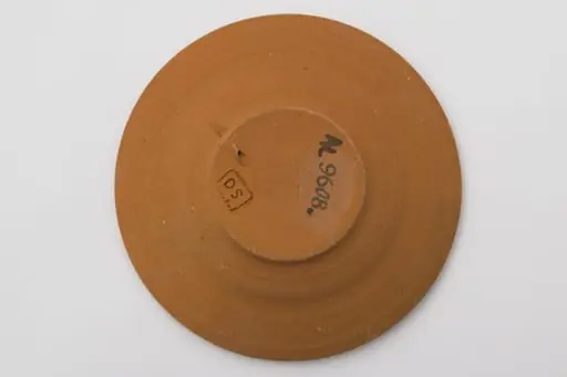 Vas ceramic cu fundul plat puțin adâncit și marginile evazate, puțin ridicate. Ornamentată cu pensula cu angoba albă. Fundul este marcat printr-o spirală din care ies alte șase spirale mici dispuse pe circumferința exterioară. Pe marginea vasului două benzi, una cu o linie întreruptă, a doua cu șase valuri întrerupte. La posterior ștanțat ”DS” încadrat într-un dreptunghi. Cromatică: fond: cărămiziu; motive: alb., by Șchiopu Dumitru