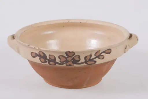 Castron mic de formă tronconică, cu baza marcată printr-un inel proeminent. Buză cu contur rotund în exterior și ascuțit în interior. Decorul floral ce constă dintr-o floare pictată cu cornul în interior, pe fundul vasului. Cromatică: fond: alb-crem; motive: galben; negru; verde., by Toc Gheorghe