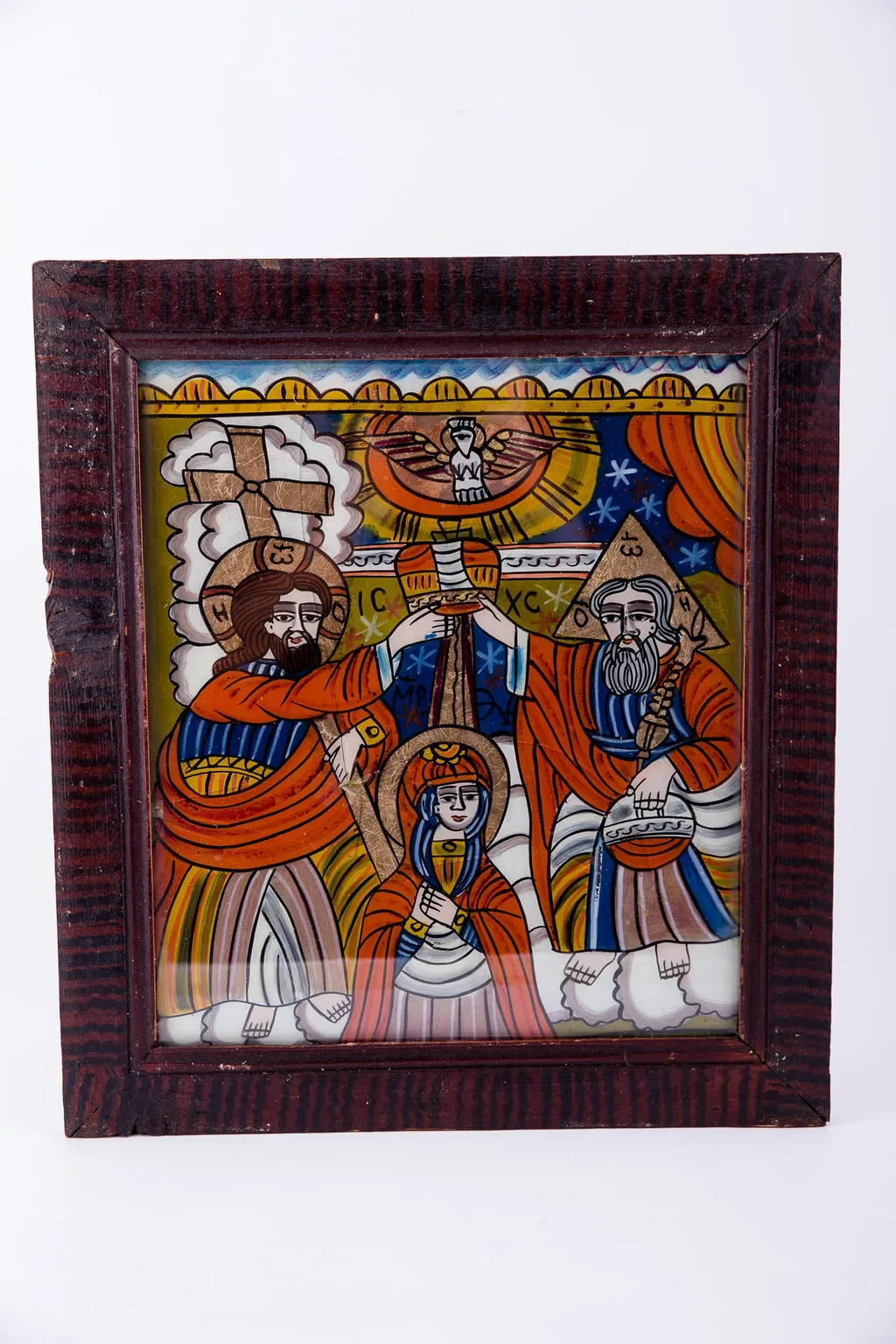Dumnezeu Tatăl, Fiul Iisus Hristos așează dimpreună coroana de împărăteasă pe capul Maicii Domnului, iar din cerurile deschise se pogoară Sfântul Duh, printr-un porumbel, pe o rază luminoasă de soare. Compoziția se împarte simetric și echilibrat în patru părți, asemenea unei cruci. Fiul - Tatăl; Sfântul Duh - Maica Domnului. Maica Domnului are înălțimea mică a unei fetițe, fiind aleasă dintre oameni. Dumnezeu-Fiul are în mâna dreaptă Crucea, iar Dumnezeu-Tatăl are globul pământesc. Maica Domnului are mâinile împreunate în rugăciune și ascultare, smerenie și primire de bunăvoie. Sunt înveșmântați în roșu vermillon-galben-albastru. În registrul îndepărtat superior este cerul albastru cu stele albe, iar în registrul inferior sunt nori albi, toată narațiunea desfășurându-se în Împărăția Cerurilor, Maica Domnului fiind ridicată de pe pământ - Adormirea Maicii Domnului. În registrul superior, tematica iconografică este încadrată de un segment decorativ, geometrizant, asemenea unor colțișori de dantelărie. Inscripția în chirilică se traduce ICXC MP Iisus Hristos Maica Domnului. Cromatică: roșu vermillon, galben, albastru, alb. Icoana ste din Țara Oltului, Șcheii Brașovului., by Unknown, 1850