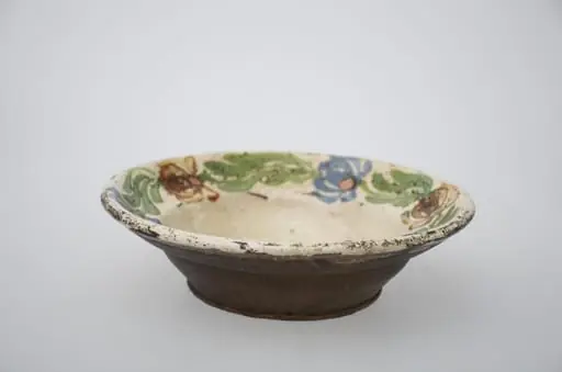 Farfurie de formă tronconică adâncă cu buza largă și decor pe fund, spre margini. Ornamentat cu motive florale. Cromatică: fond: alb; motive: maro; verde; albastru., by Unknown